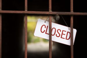 Closed sign over a rusty gate